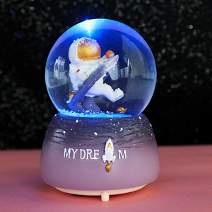 Astronaut snow globe music box with blue LED lights and My Dream text on purple base