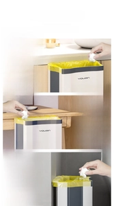 Collapsible hanging bin shown on cabinet doors, desks and bathroom walls for waste disposal