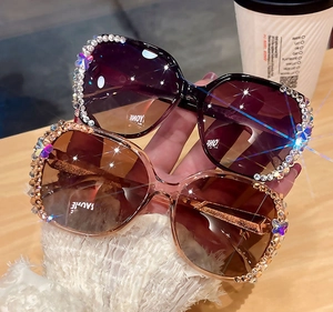 Détail de lunettes de soleil oversize avec strass et accents de papillons colorés