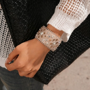 Gros plan d'un large bracelet manchette en cuir avec strass sur le poignet