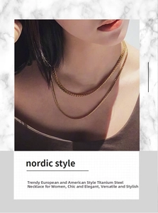 Detail view of a double-layered gold titanium curb chain necklace in nordic style