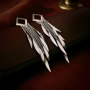Close-up of silver leaf tassel earrings with square studs and sleek metallic finish