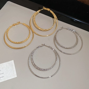 Detail view of 18k gold and silver plated double hoop earrings with textured finish