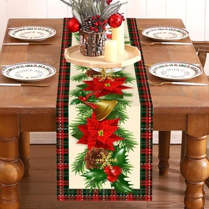 Christmas table runner with poinsettia pine cones and bells on a wooden dining table