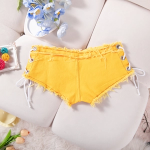 Dettaglio degli shorts di denim gialli con lacci laterali e orlo con frange consumate