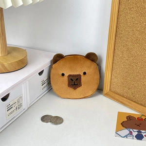 Close-up of plush capybara coin purse with bead chain and soft brown texture details