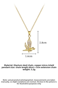 Macro shot of gold bird pendant necklace with sparkling white zircons and dimensions