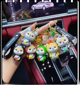 Close-up of Shiba Inu zodiac keychain collection held in a car showing six cute animal costumes