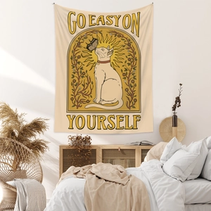 Detail view of Bohemian cat tapestry with butterfly and sun hanging on a bedroom wall
