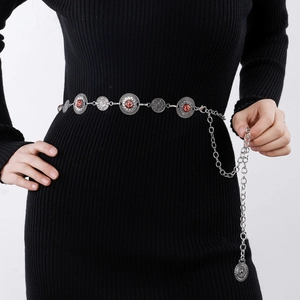 Detailed view of vintage silver waist chain with red stones on black dress