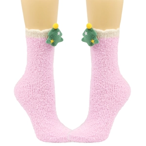 Nahaufnahme der rosa Plüschsocken mit weißem Pelzbesand und grünem Weihnachtsbaum