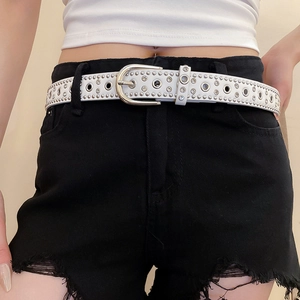 Close-up of white leather belt with silver rivets and rhinestones in trendy punk style