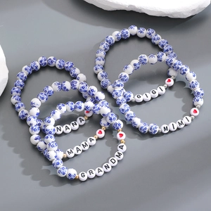 Dettaglio di perle in porcellana bianca e blu con scritte Nana Mama Grandma Gigi Mimi