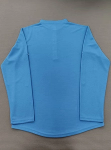 Detail showing blue long sleeve polo shirt with waffle texture and breathable fabric design