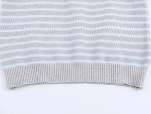 Dettaglio del tessuto a maglia a righe grigie e celesti con un bordo a costine