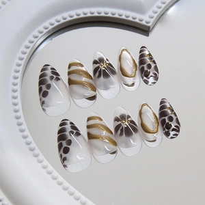 Elegant almond press-on nails with black floral and gold leopard patterns on clear base