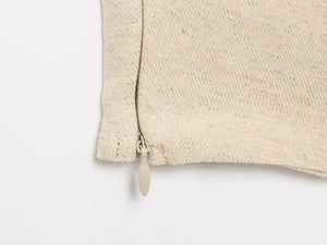 Detail shot of the beige linen blend fabric featuring a hidden zipper and woven texture