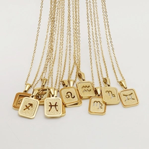 Groupe de colliers avec pendentifs zodiaque en acier plaqué or 18 carats sur fond blanc