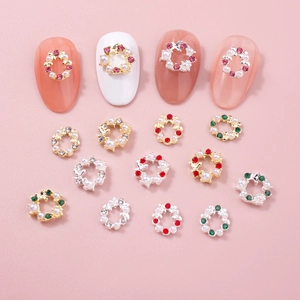 Charm's nail art couronne de Noël avec strass colorés et perles sur fond rose pastel