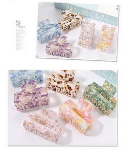 Detailed view of square marble pattern hair claws in colorful acrylic material