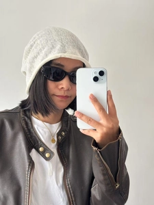 Detail of white breathable 100% linen knit beanie paired with trendy black sunglasses