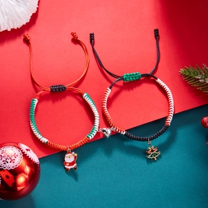 Detail of Christmas braided bracelets with Santa and tree charms and heart magnetic clasp