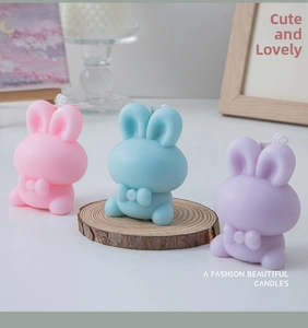 Close-up of pink, blue and purple rabbit-shaped scented candles with bow tie details