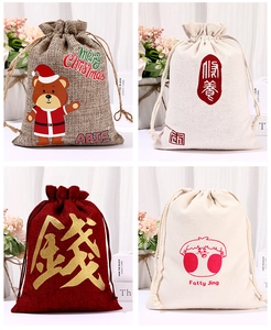 Detail of four linen Christmas drawstring gift bags with diverse festive patterns and motifs