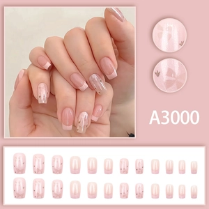 Short French press-on nails in pearlescent pink with sweet bow designs and 24 pieces