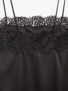Détail du caraco noir en satin avec bordure en dentelle délicate et fines bretelles