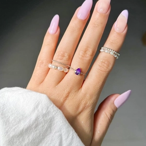 Détail d'un ensemble de bagues avec pierre goutte violette et perles blanches