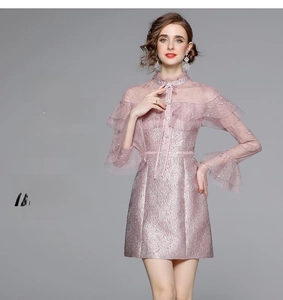 Détail de la robe en dentelle rose avec manches à volants et col montant texturé