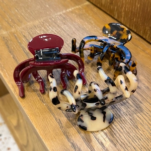 Detailed view of handmade acetate hair claws in wine red and tortoise patterns