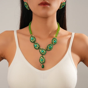 Vintage gold necklace and earrings set with green teardrop beads and diamond accents