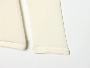 Macro shot of knitted off-white double-layer long-sleeve T-shirt hem and seam detail