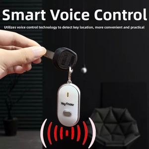 Close-up of a white smart key finder with steel ring held by hand in home setting