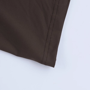 Gros plan d'une couture à double aiguille sur tissu tricoté marron foncé élégant