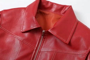 Detail of red PU leather jacket showing lapel, metal zipper, and white contrast stitching