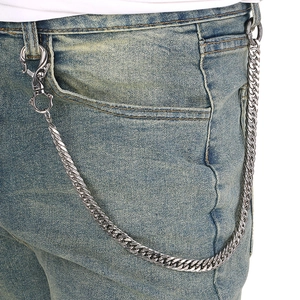 Detail of silver twisted Cuban link pants chain with lobster clasp on blue denim jeans