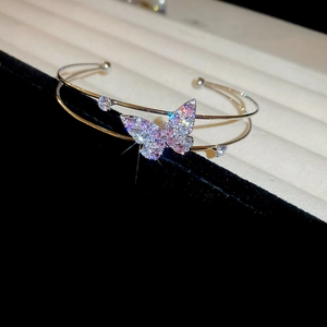 Macro shot of silver butterfly bangle encrusted with pink and white cubic zirconia