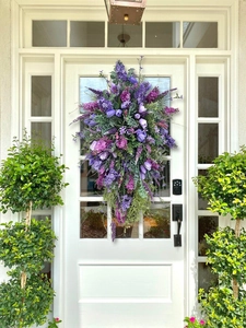 Close-up of a purple tulip and lavender teardrop wreath hanging on a white front door