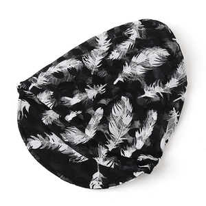 Detailed view of breathable black lace beanie with white feather print for summer wear