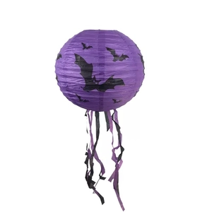 Dettaglio lanterna di carta viola per Halloween con pipistrelli neri e lunghe nappe decorative