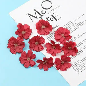 Detailed macro view of 11 dark red silk faux plum blossom heads for DIY hair accessories