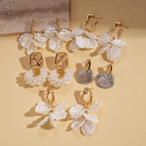 Detail view of pearl and flower petal drop earrings set with gold finish and stone props