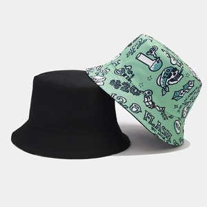 Detail of a reversible bucket hat with black solid side and graffiti print with skull motifs