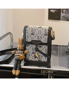 Detailed view of houndstooth crossbody bag featuring bear print and cute rabbit pendant