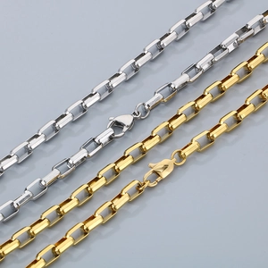 Detail of gold and silver box chain necklaces with lobster clasps on a grey background