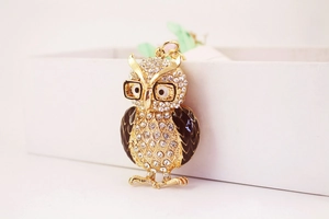 Détail du porte-clés hibou avec métal doré, ailes en émail noir et strass étincelants
