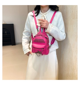 Detail of rose pink PU leather mini backpack with metal studs and cross pendant decoration